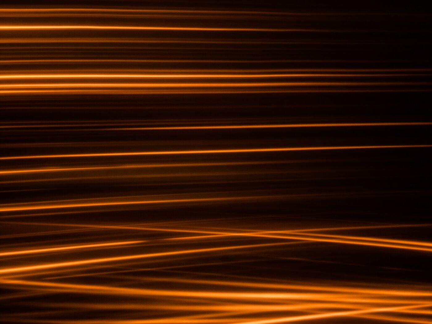 Bernsteinfarbene Lichtbahnen auf dunklem Grund als Sinnbild für Performance und Datenfluss